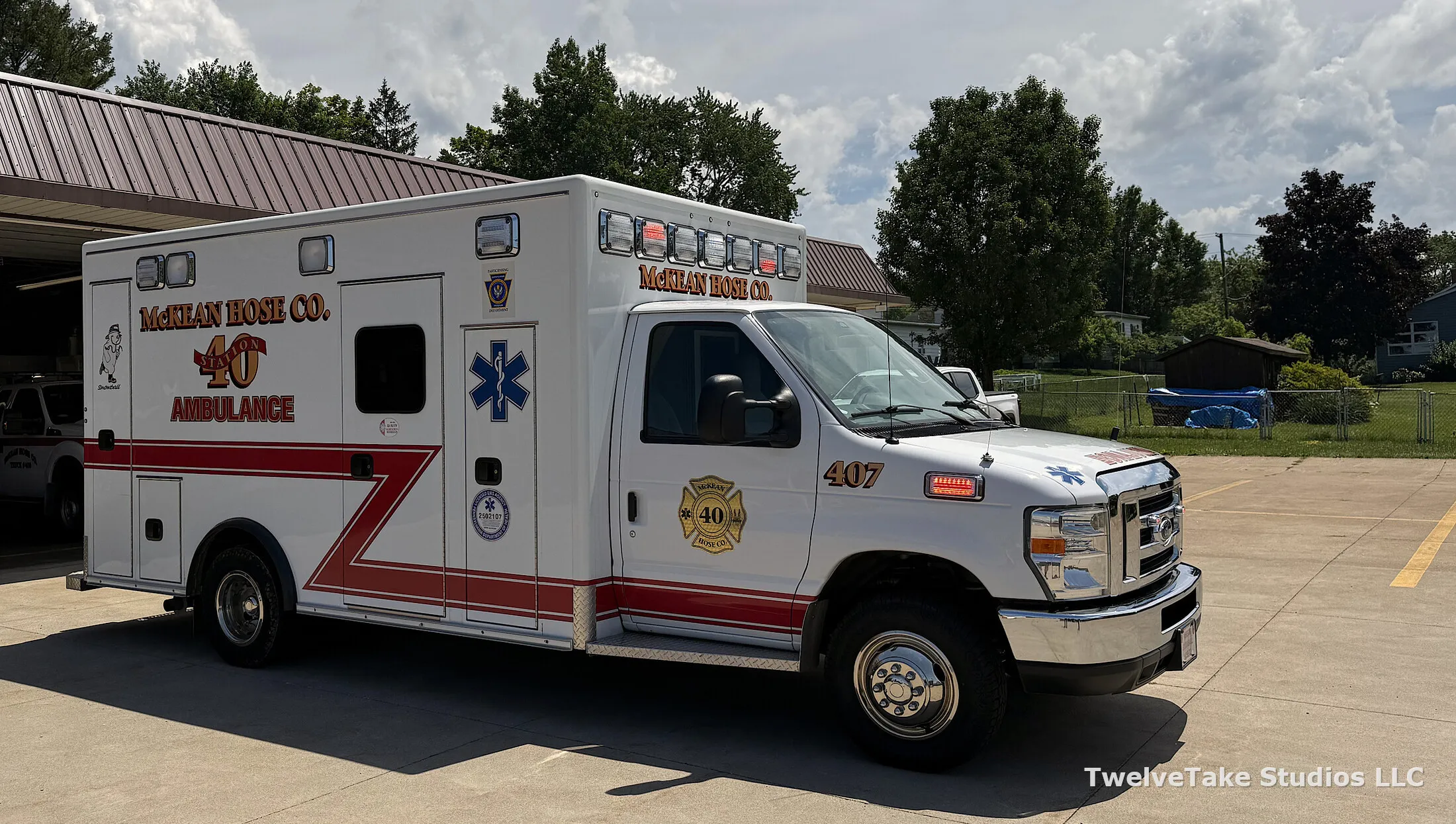 Ambulance 407 parked outside the station, lettered McKEAN HOSE CO. STATION 40 AMBULANCE, with 407 on the cab door.