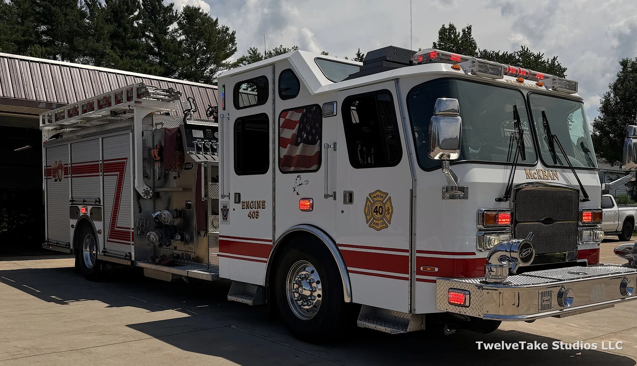 Engine 403 angled toward the camera on the pavement outside with its warning lights lit, ENGINE 403 lettered on the cab door beneath the McKean Hose Co. crest and an open bay door behind it.