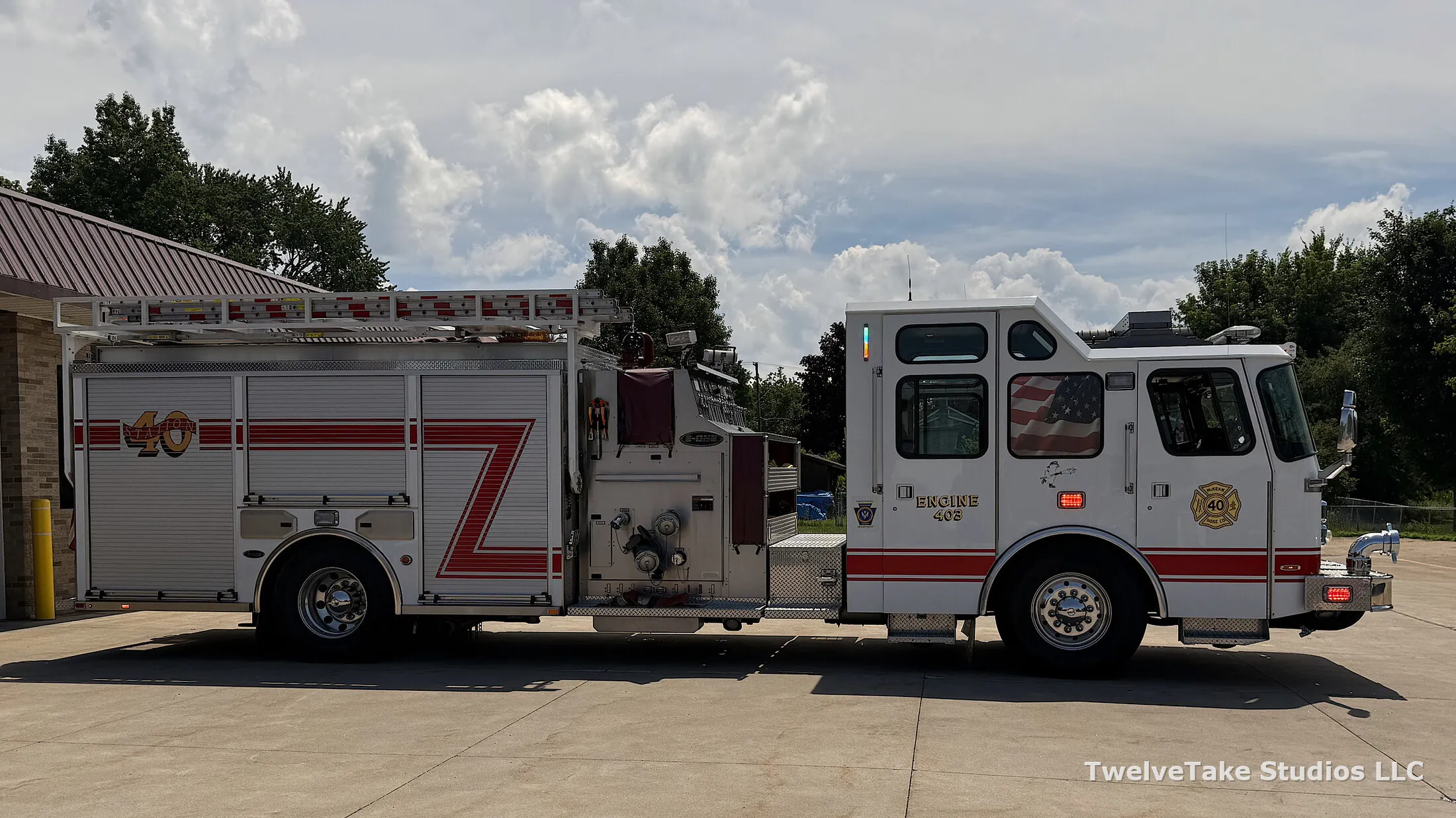 Full side view of Engine 403 with ladders racked the length of the body, roll-up compartment doors closed and STATION 40 lettered above the wheel well.