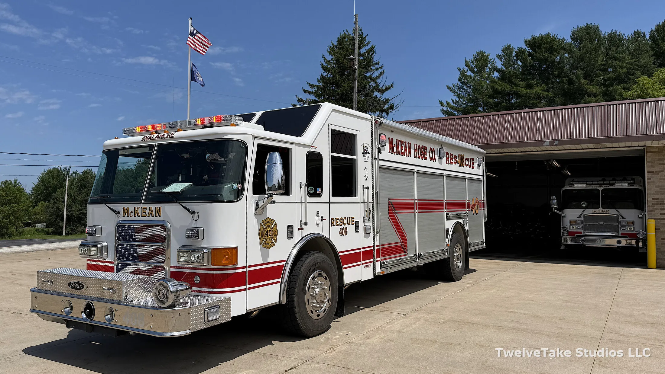 Rescue 408 on the pavement outside with its warning lights lit, McKEAN HOSE CO. RESCUE 408 lettered in red and gold along the body and another engine sitting inside the open bay behind it.